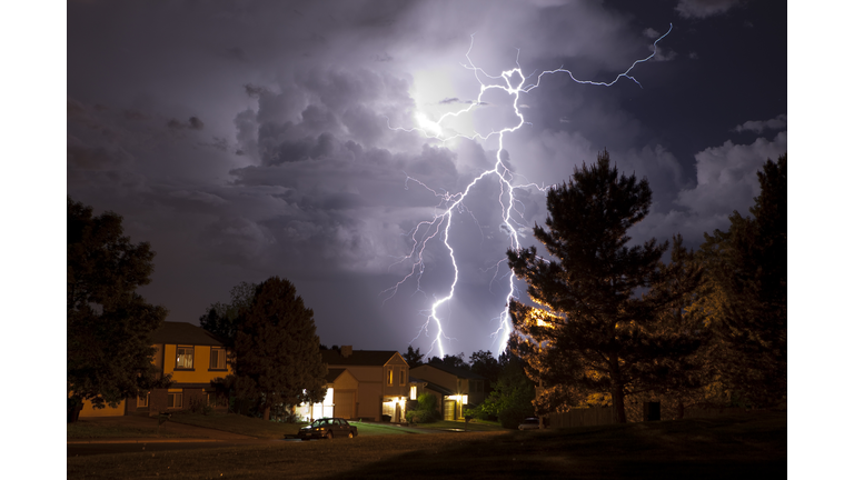 Lightning bolt and thunderhead storms over Denver neighborhood homes
