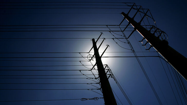 Maze of power lines against deep blue sky