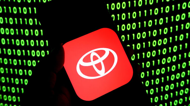 In this photo illustration, a Toyota car brand logo is