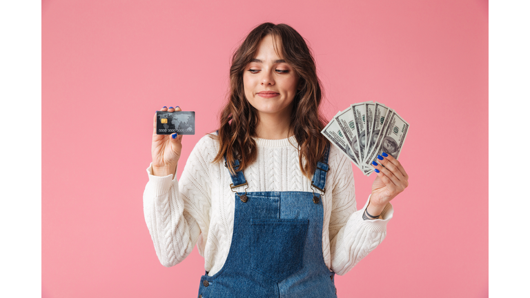 Portrait of a confident young girl holding money banknotes