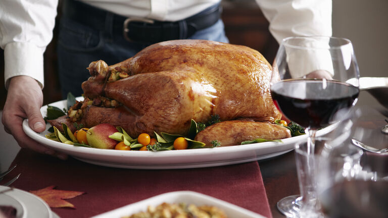 Man serving turkey dish at table