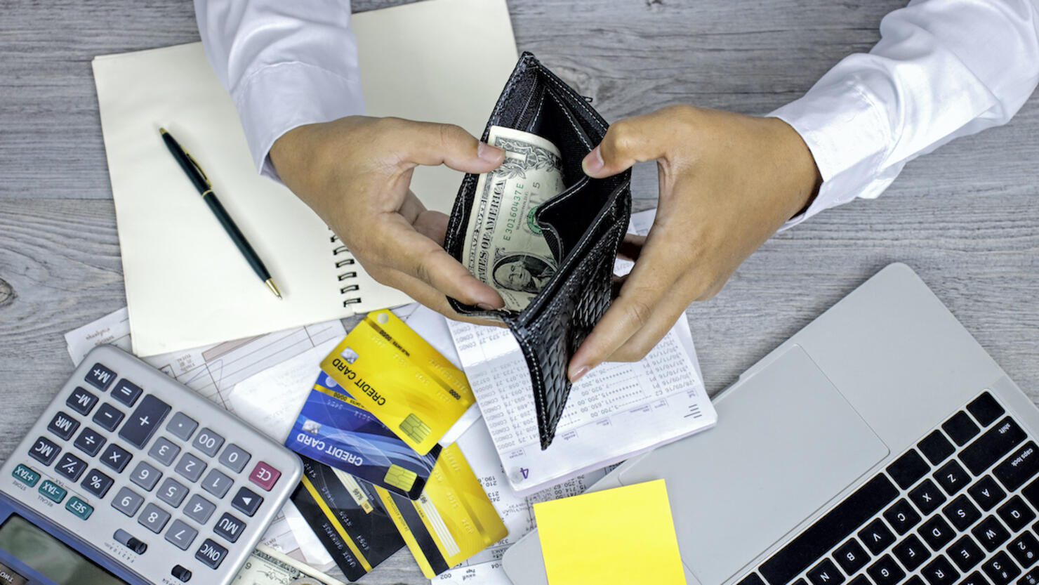 Man hand opening wallet, debt expense bills monthly and credit card at the table in home office , managing payroll,money risk financial concept