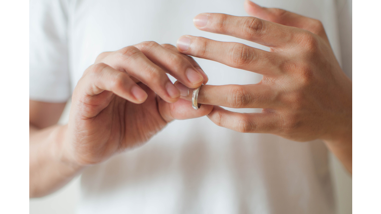 A young man is removing his wedding ring a concept of relationship difficulties