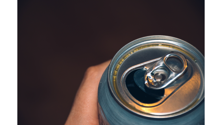 Close-Up Of Hand Holding Drink Against Black Background