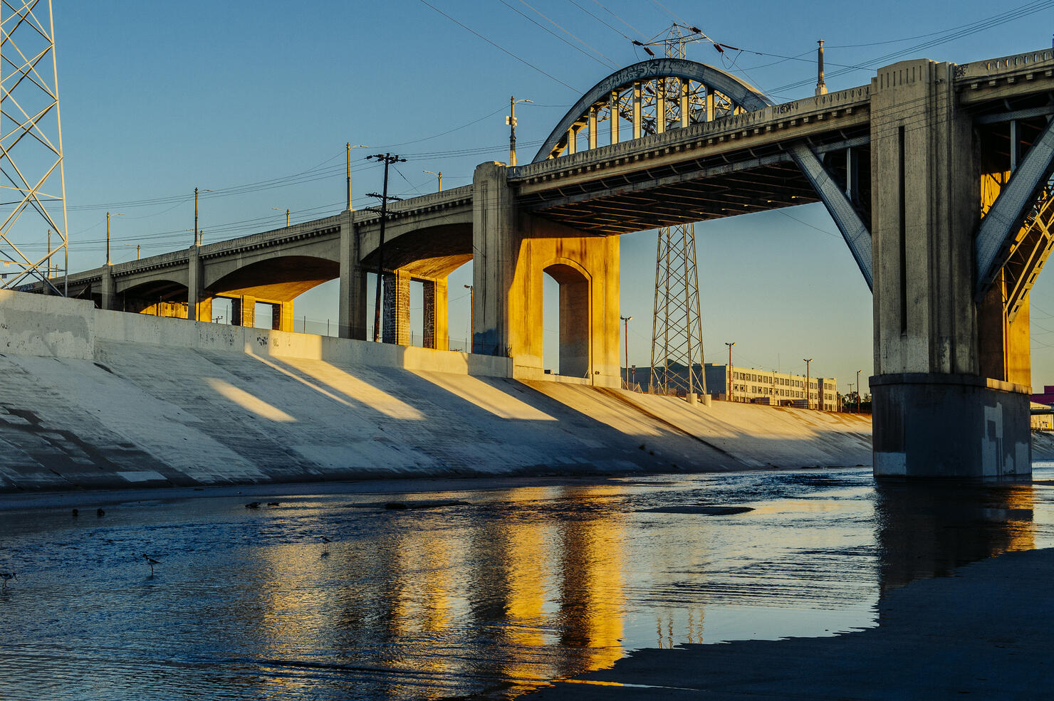 Sunlight on Los Angeles river embankment and 6th street bridge, Los Angeles, California, USA