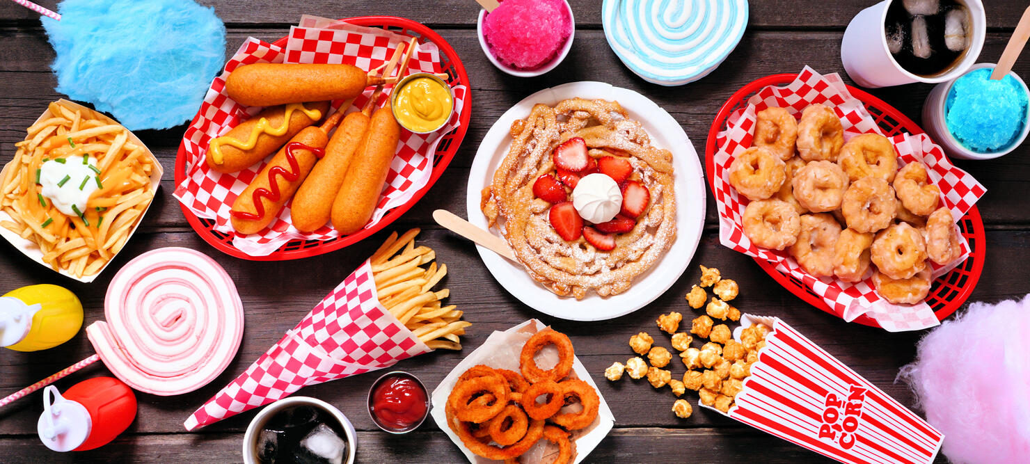 Carnival theme food table scene over a dark wood banner background