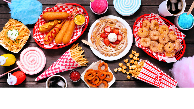 Carnival theme food table scene over a dark wood banner background