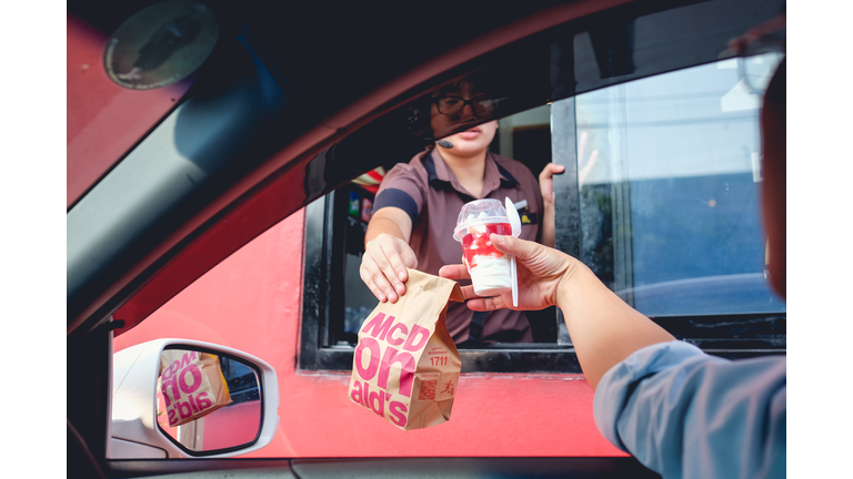 Bangkok, Thailand - Mar 4, 2017: customer receiving hamburger and ice cream after order and buy it from McDonald's drive thru service