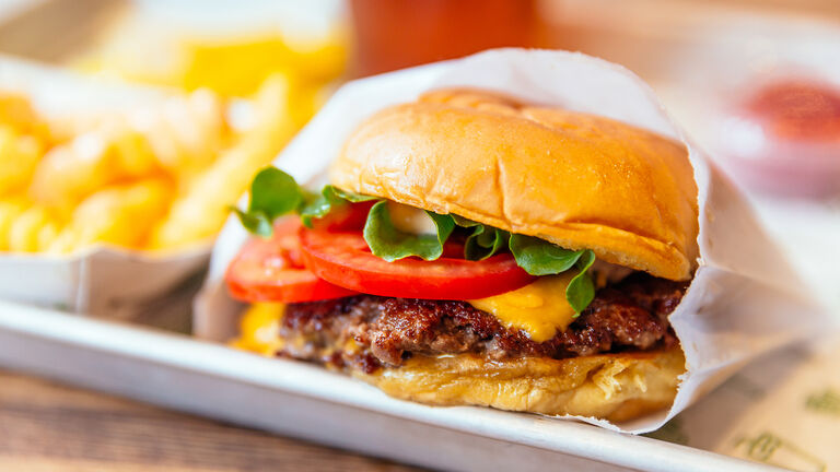 Close up of juicy cheeseburger with fresh tomatoes