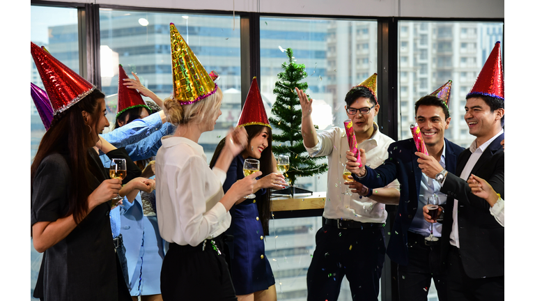 Business men and women with glasses of champagne celebrating Christmas and New Year