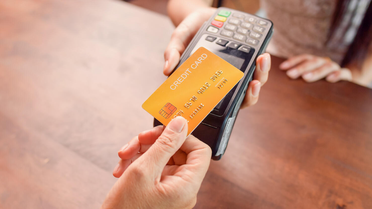 Person paying with a credit card using a credit card terminal