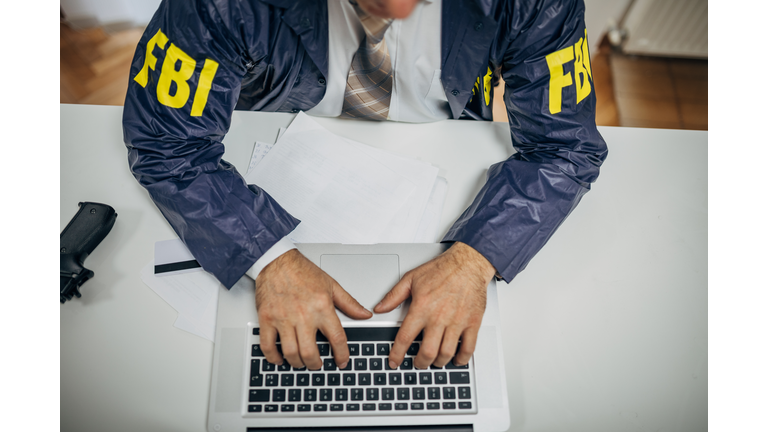 A senior FBI agent uses a laptop in the office