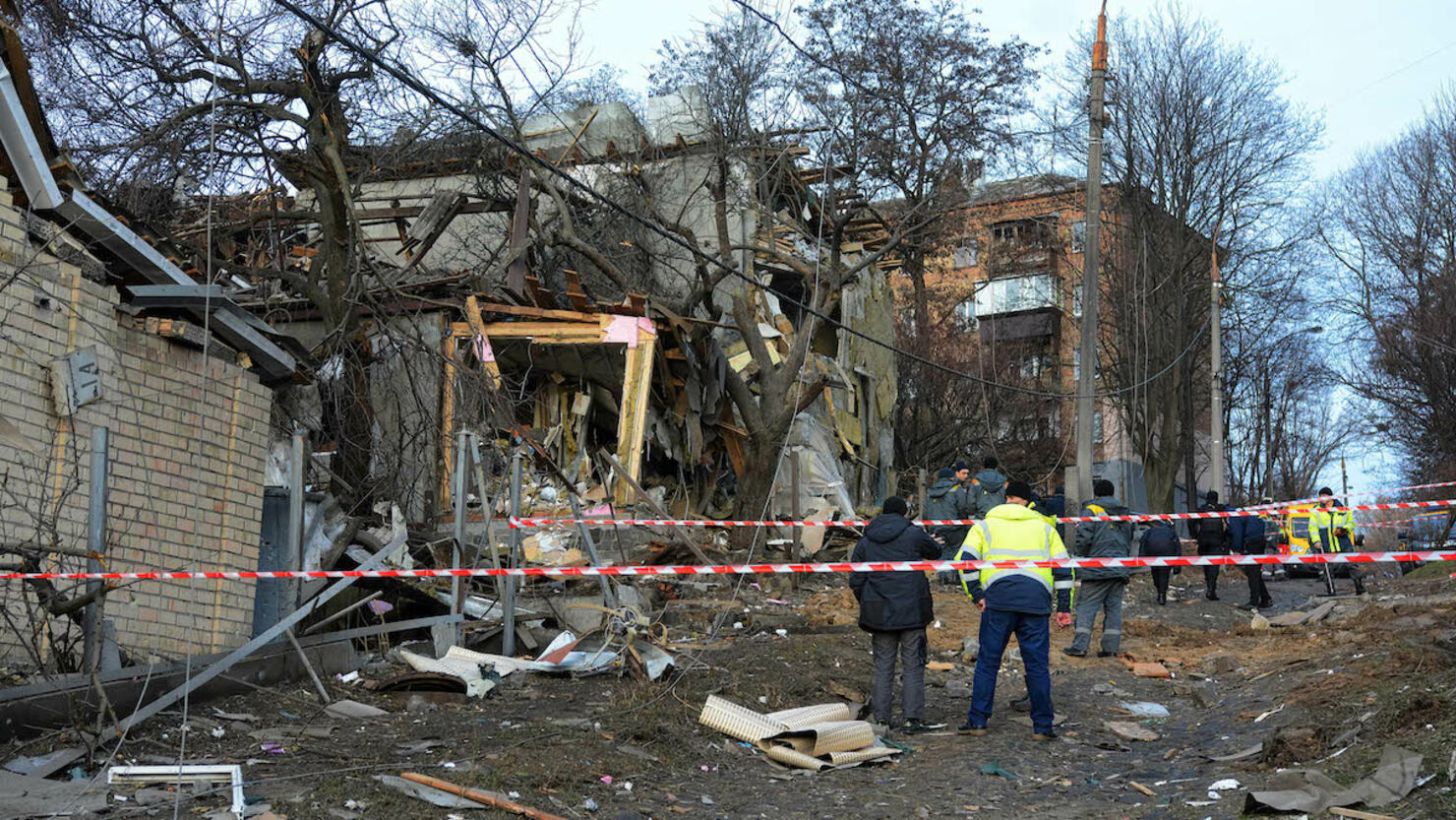 Rescuers examine a destroyed apartment building after a