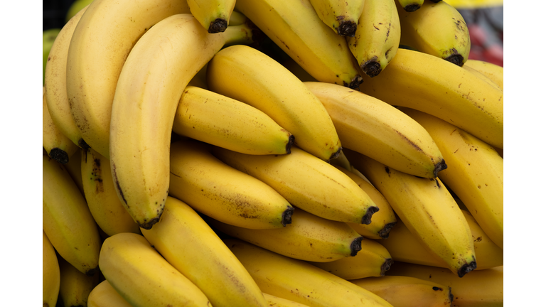 Ripe yellow bananas at the shopping market. Fruits that are good for health. The concept of vegetarianism, veganism and raw food. Vegetarian, vegan and raw food and diet. Food background, bright color. Retail sale of seasonal products.