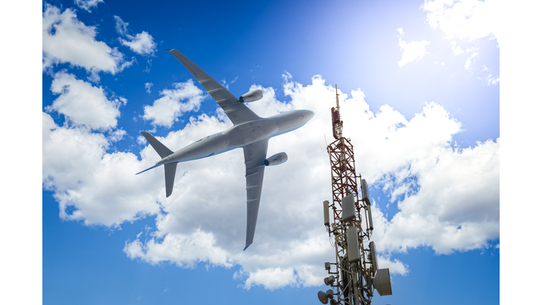 Mobile phone cell tower with 5G on the C Band frequencies with aircraft on the background