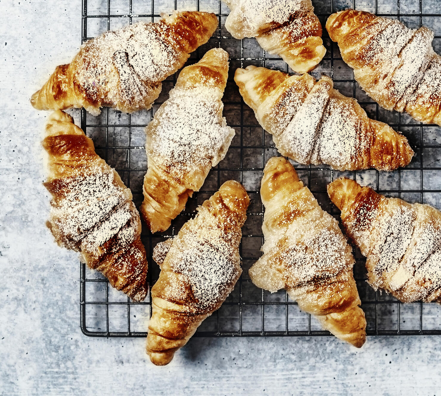 Croissants on a cooling rack on gray background