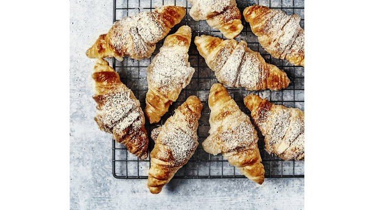 Croissants on a cooling rack on gray background