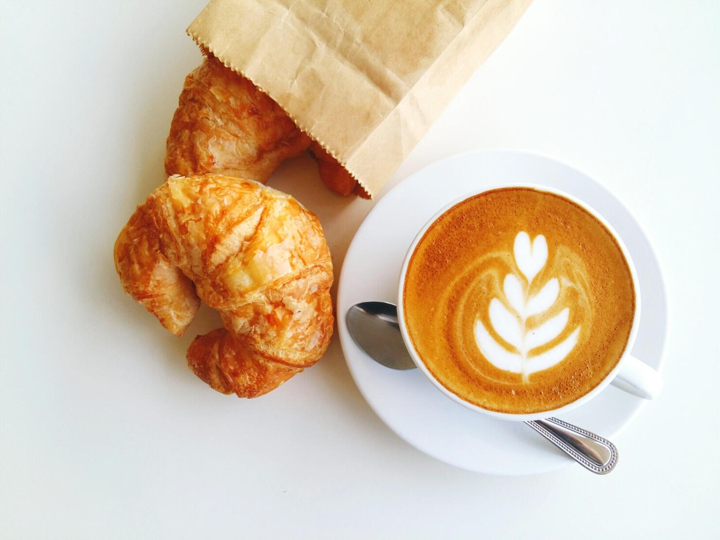 High Angle View Of Cappuccino With Croissant On White Background
