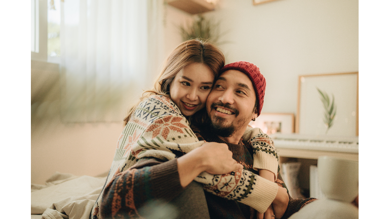 Happy young couple relaxing talking laughing drinking coffee tea