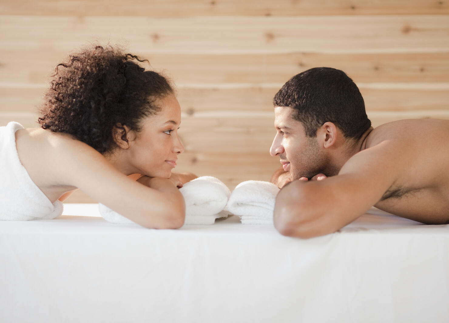 Couple laying face to face on massage table