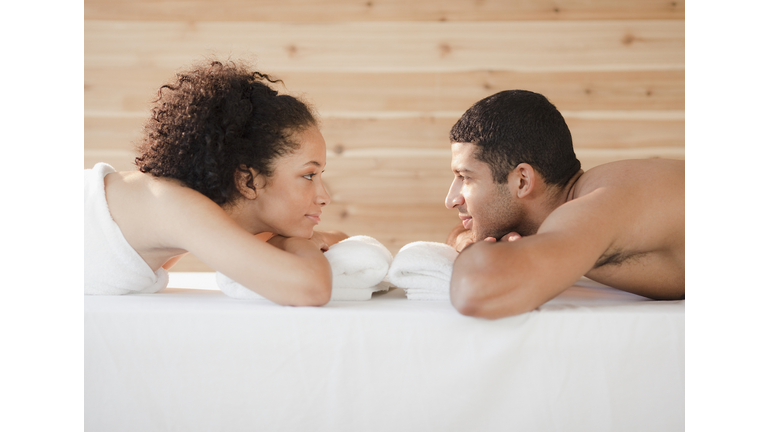 Couple laying face to face on massage table