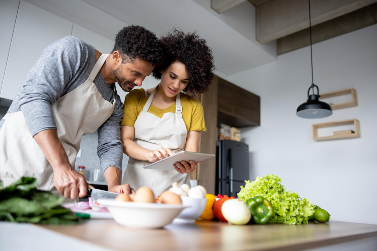 Couple cooking together at home following an online recipe