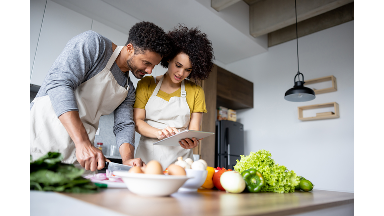 Couple cooking together at home following an online recipe