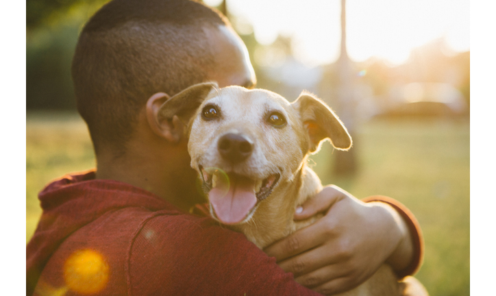 rear view of a young man hug his small dog