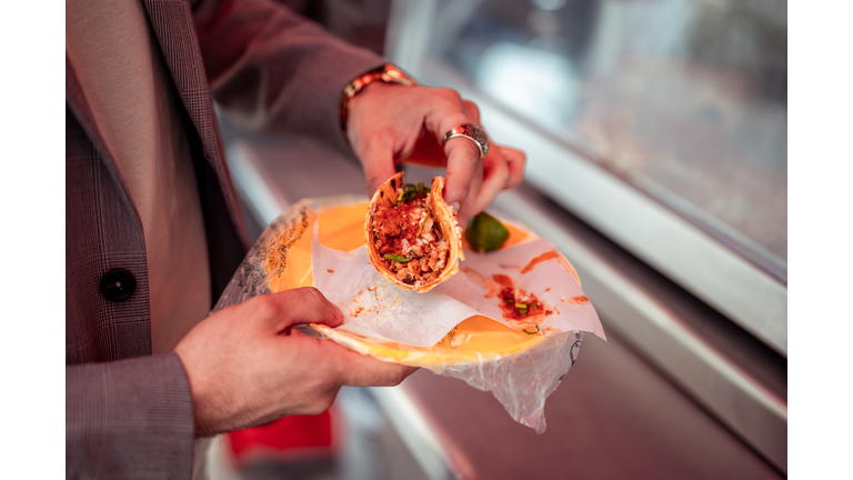 Close up of human hand holding tacos