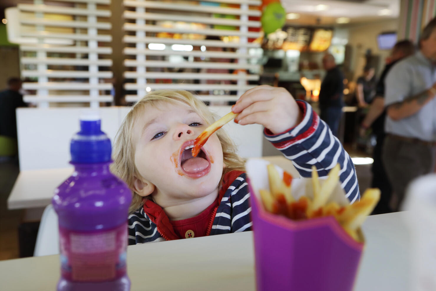 Toddler eating fast food in restaurant