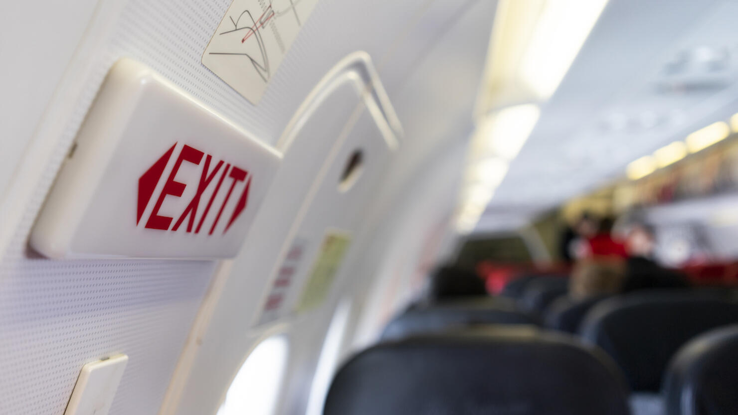 close up shot sign in airplane near emergency exit doors