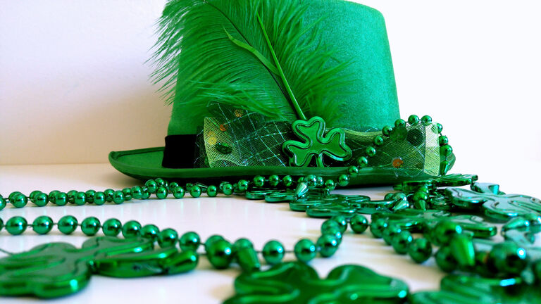 Green Hat With Feather And Beads Necklace For Saint Patrick Day Celebration.