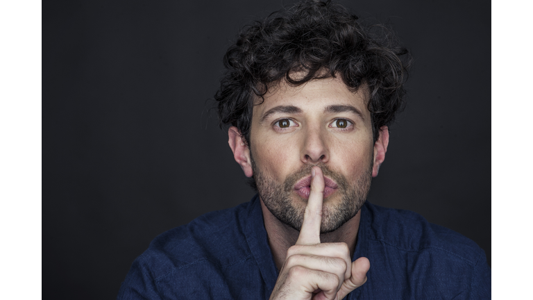 Man silencing with finger held to lips