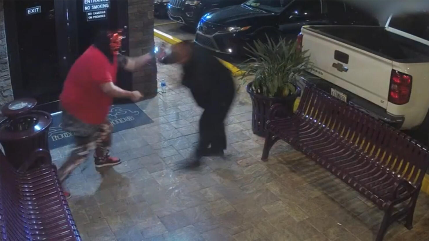 Man wearing devil mask fights security guard