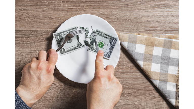 Hands of unknown person cutting banknote