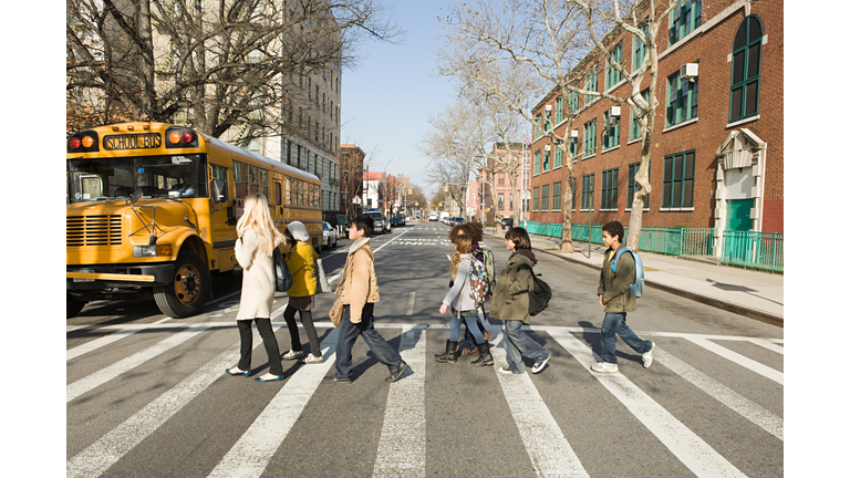 Teacher and pupils crossing road