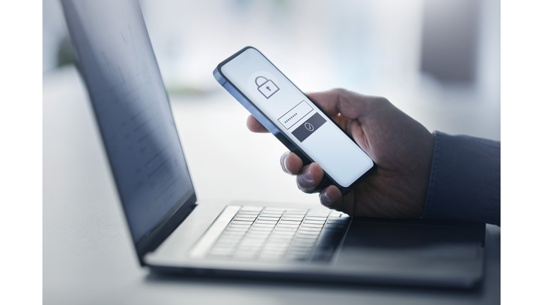 Man holding smart phone with data security on display at office