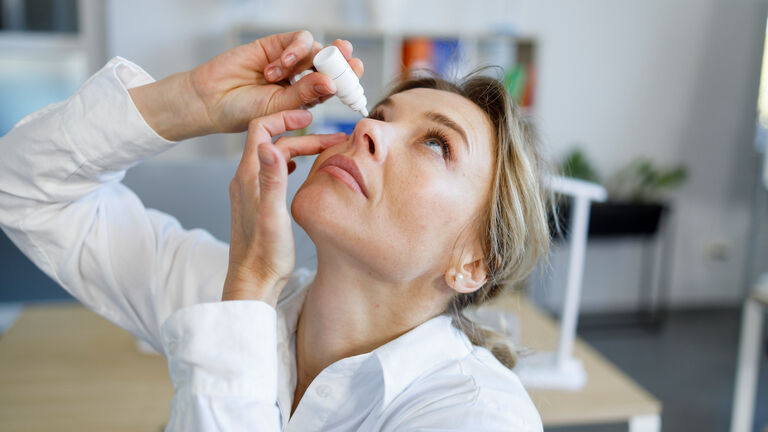 Business woman office worker dripping eye drops