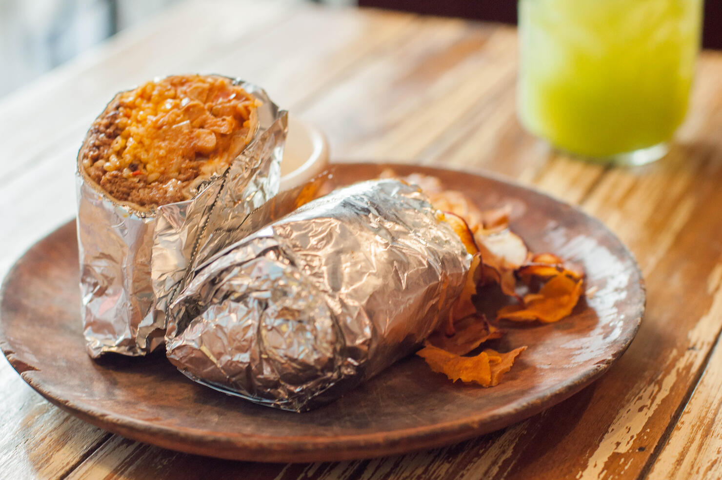 A close-up view of freshly made burrito on a wooden plate