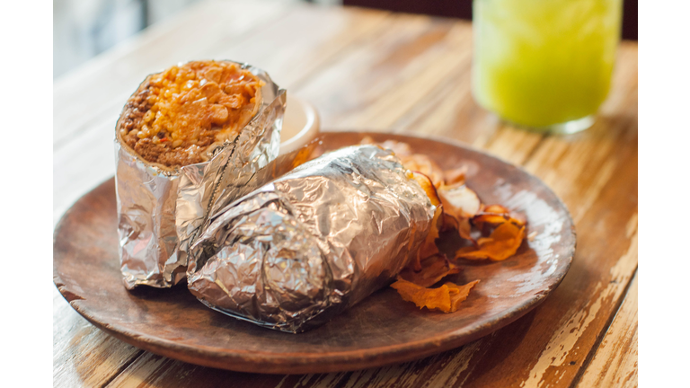 A close-up view of freshly made burrito on a wooden plate