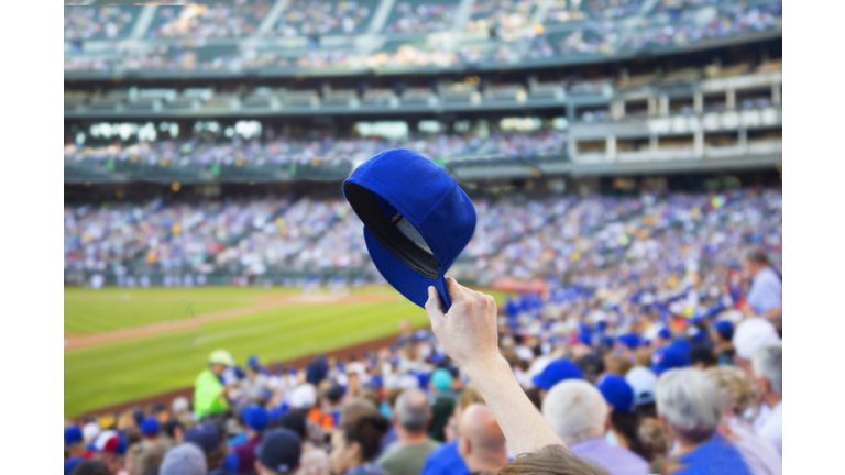 Man holding up baseball cap.