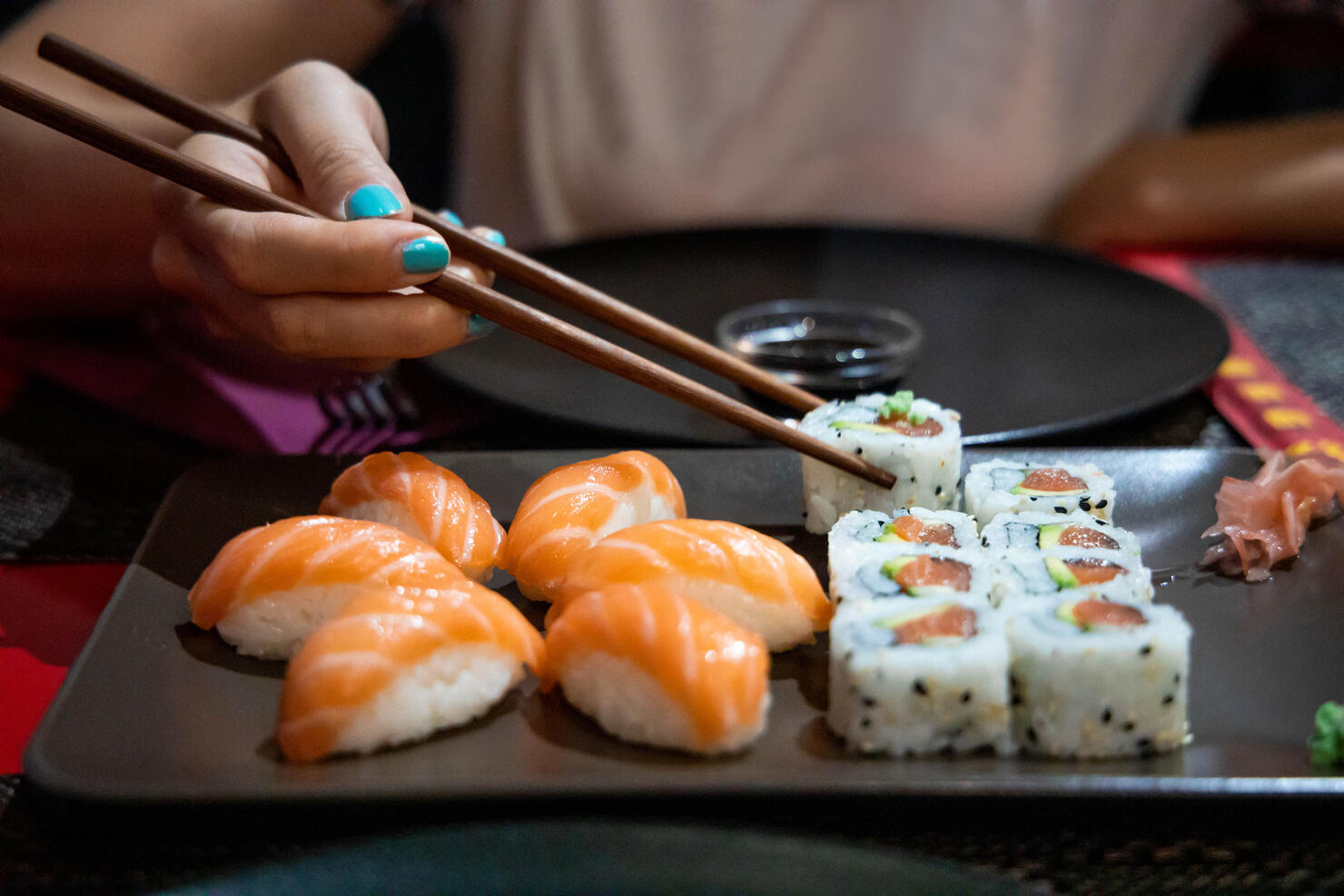 Eating Sushi with chopsticks in Japanese restaurant.