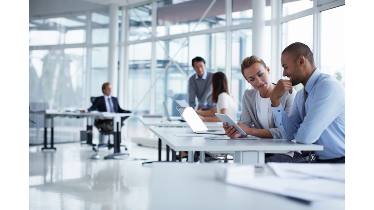 Colleagues discussing over digital tablet