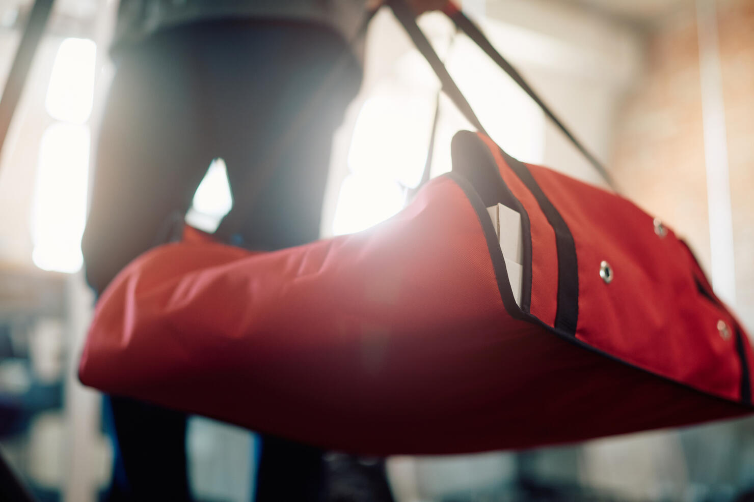 Close-up of pizza delivery person carrying thermal bag.