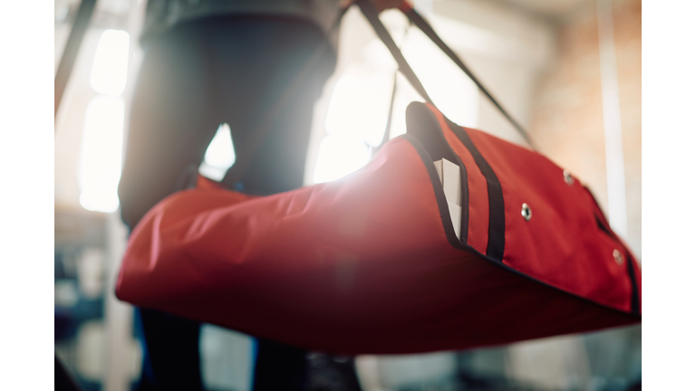 Close-up of pizza delivery person carrying thermal bag.