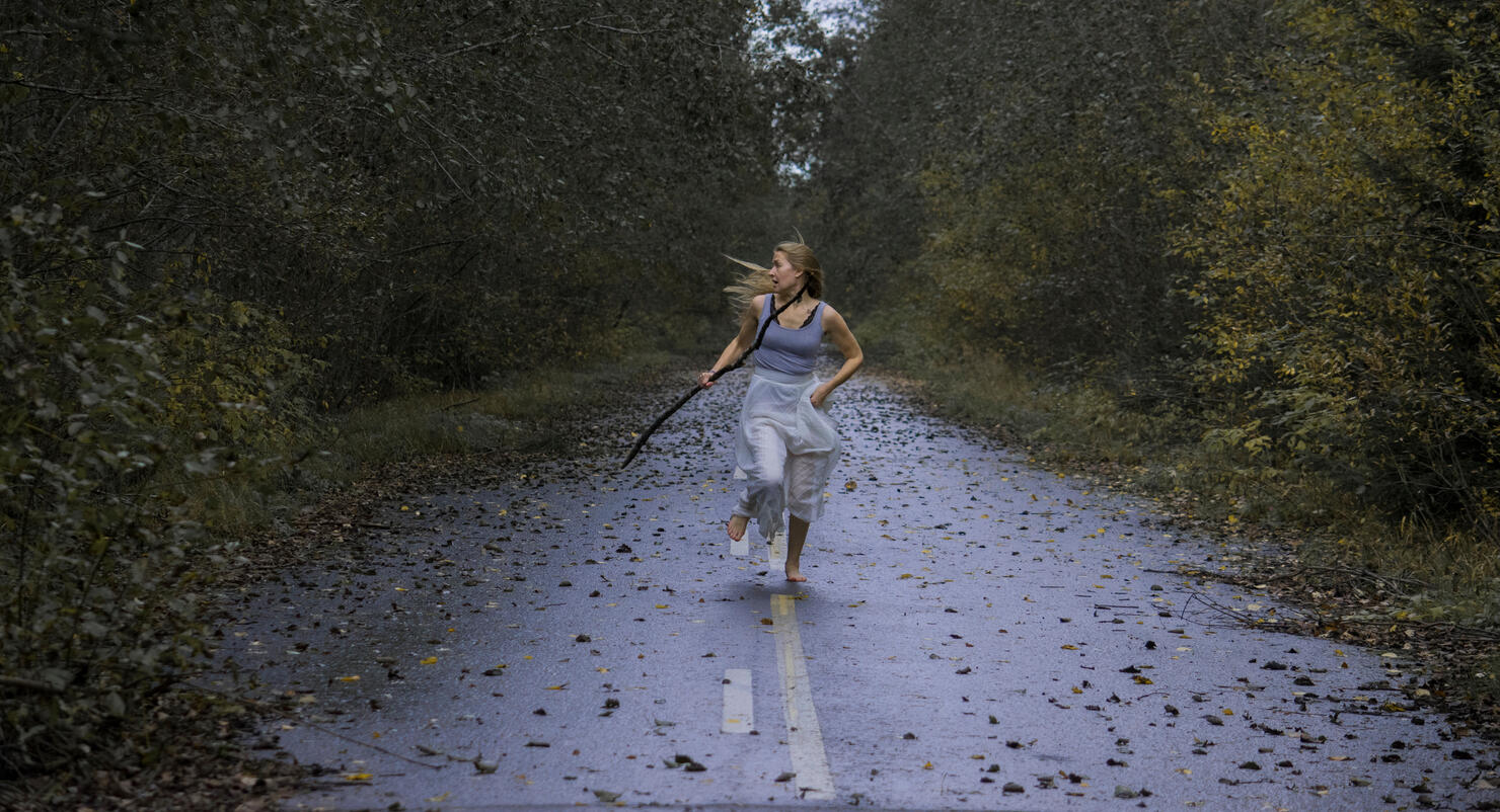 Scared Young Woman Running On Footpath In Forest