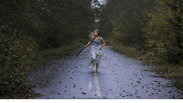 Scared Young Woman Running On Footpath In Forest