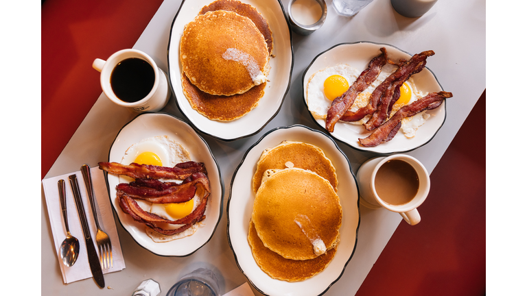 American breakfast at the diner with fried eggs, bacon and pancakes