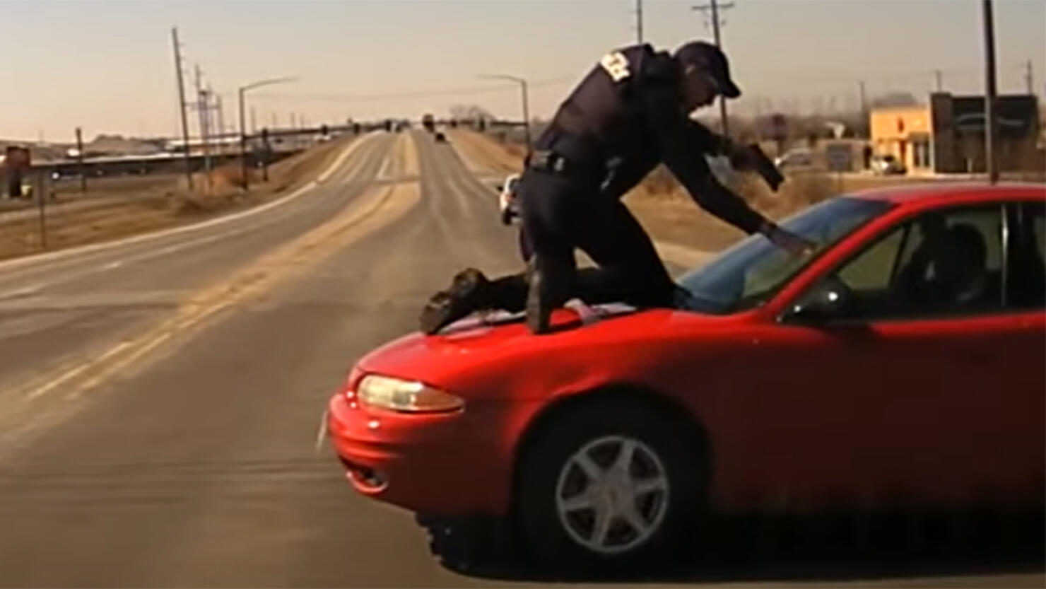 Carroll Police Officer Patrick McCarty on the hood of a car