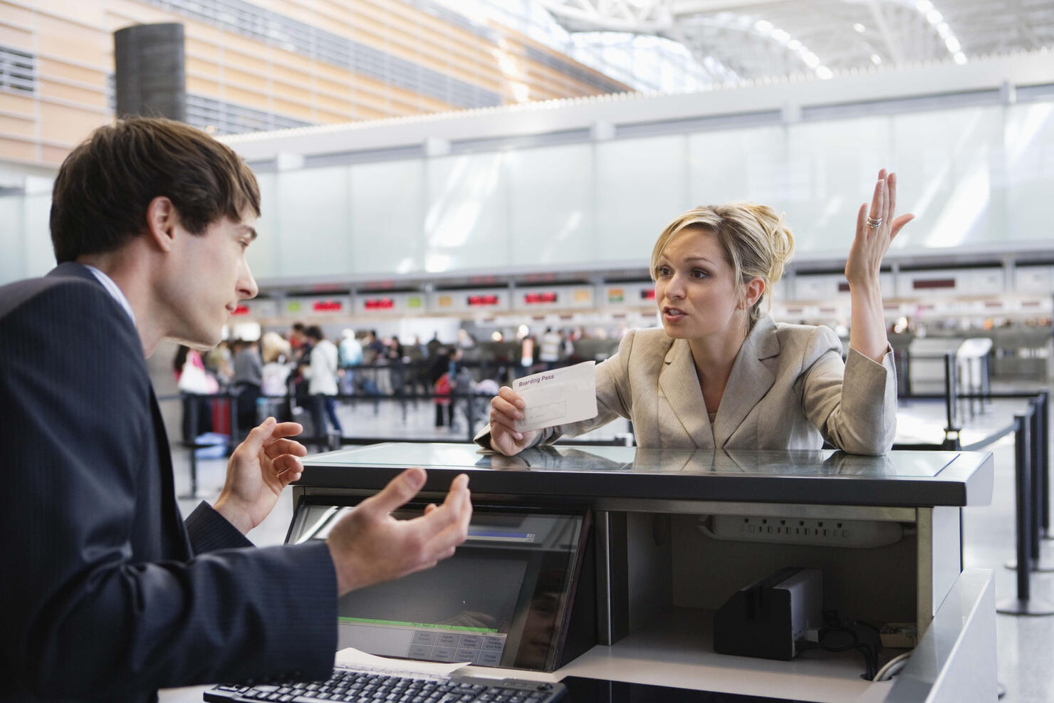 Upset businesswoman checking in at airport ticket counter